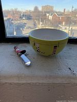 Bowl and spreader knife displayed on a window sill showcasing Christmas stocking designs.