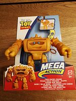 Front view of the orange Chunk figure on its original backing card showing the character with a happy face expression and large arms.