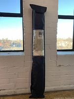 Full view of the black carrying/storage bag for the Ikea tent with label.