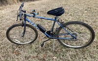 Side view of men's blue Huffy Baywatch bicycle showing frame, seat, kickstand, pedal, and front wheel