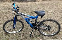 Side view of blue Next Power Climber bike showing blue and white frame with suspension and thick tires.