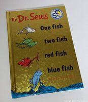 Front cover of special edition Dr. Seuss book featuring shiny gold with colorful fish and 50th anniversary party edition label.
