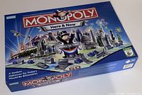 Closed Monopoly Here & Now edition board game box with thematic artwork