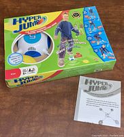 Photo of Hyper Jump game box with electronic ball visible in window and instruction manual placed beside box