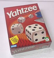 Front view of the sealed red Yahtzee game box with large dice graphics and title prominently displayed.