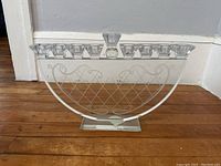 Front view showing the full menorah with 9 glass candle holders and the metalwork base with lattice design.