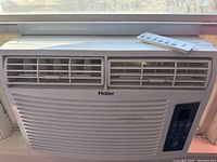 Front view of Haier 10000 BTU window air conditioner unit installed in a window.