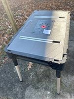 Angled side view of Husky construction work table showing top, legs, and shadow