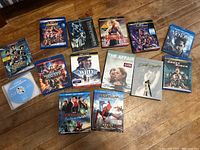 All 14 movies spread on floor with visible cover art including Marvel superheroes and drama films