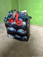 Reusable bags in a bundle showing a bag with blueberry design and others inside