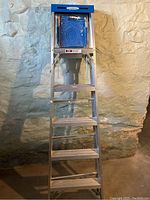 Front view of Werner 6-foot aluminum stepladder showing six wide steps and blue top tool tray.