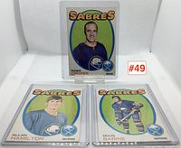 Three Buffalo Sabres hockey cards in protective sleeves: Roger Crozier, Allan Hamilton, Doug Barrie.