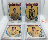 Four California Golden Seals hockey cards displayed upright in protective sleeves. Cards include Ron Stackhouse, Carol Vadnais, Gerry Pinder, and Gary Croteau.