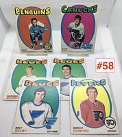Photo of all six hockey cards arranged in two rows showing full fronts with player images and team names: Penguins, Canucks, Blues, Flyers. Condition visible as lightly used with minor wear.
