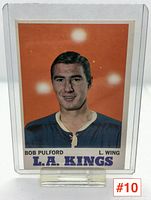 Front view of Bob Pulford 1969-70 L.A. Kings hockey card in protective sleeve with clear stand; shows player portrait on orange background with text.