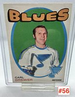 Front of 1970-71 Carl Brewer hockey card showing player in Blues uniform with green oval background and 'BLUES' title.