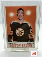 Front image of Don Awrey hockey card showing player portrait in Bruins uniform with orange background