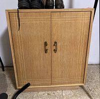 Front view of Lane cedar lined cabinet with two doors closed, brass handles, visible wood grain and etched lines design.
