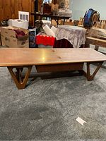 Full side view of coffee table showing trapezoid legs and overall profile