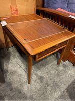 Pair of wooden tables with one showing clear protective top