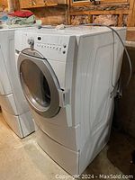 Side front angle close-up of Maytag washing machine showing door and controls.