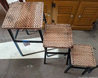 Top view showing the woven natural fiber texture of the three stackable metal stools and their height difference.