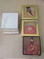 Top view of the four coaster sets stacked, three Asian themed sets and one set of marble coasters.