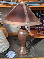 Full view of the vintage mica table lamp showing the urn-shaped metal base and conical mica shade with metal reinforcements.