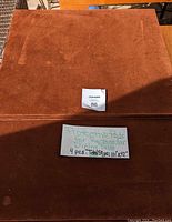 Four rectangular table protective pads stacked and displayed with a sign showing dimensions 101 x 42 inches and note about 4 pieces.