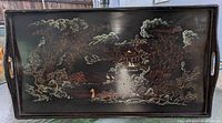 Full view of rectangular black wooden tray with hand painted Asian design showing trees, clouds, and pavilion with figures. Integrated handles on short sides visible.