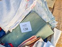 Close-up of folded vintage linens showing texture, colors, and patterns such as embroidery and lace edges.