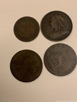Four copper coins arranged on white background, front sides visible with dates and inscriptions, showcasing different coin designs and wear.