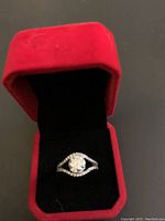 Ring displayed inside red velvet box with black interior