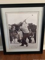 Full view of framed photo of Jack Nicklaus golfing, includes frame and matting.