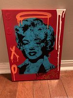 Front view of the painting showing full pop art portrait on red canvas