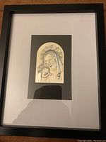 Framed artwork showing sterling silver relief Madonna and child mounted on black matte background.