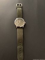 First timepiece front view showing green dial with white numerals, brand "OCHSTIN", date window, and green leather strap.