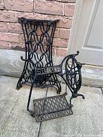 Full view of the Singer sewing machine iron base parts including frame and treadle pedal.