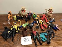 Overview of lot with 15 figurines and accessories spread on wooden table