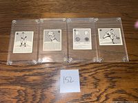 Four vintage 1952 Parkhurst Frostade baseball cards displayed front side up in clear plastic cases on a wooden surface with a small paper note '152'.