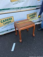 Photo of wooden end table with a tape measure showing approximate width of 23 inches.