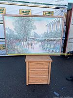 Framed painting on top of a wooden cabinet with tape measure showing width around 63 inches.