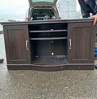 Front view of dark wood TV rack showing cabinets and open shelving