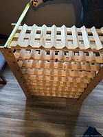 Top view showing width measurement tape across wine rack and multiple horizontal slats to hold bottles.
