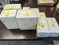 Seven boxed Precious Moments figurines arranged on a table, showing original boxes with the Precious Moments and Enesco branding.