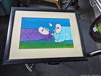 Framed surrealist oil painting with two abstract humanoid figures, purple and light blue, on textured canvas with visible artist signature.