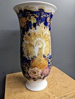 Front view of the cobalt blue porcelain vase with yellow bird floral design and gold accents