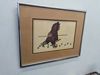 Framed art print showing an Inuit hunter with footprints, matted and under glass in a metal frame.