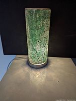 Photo of green crackle glass cylindrical lamp illuminated to show texture and light diffusion