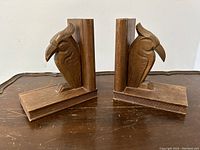 Front and side views of both carved wood parrot bird bookends showing design and shape.